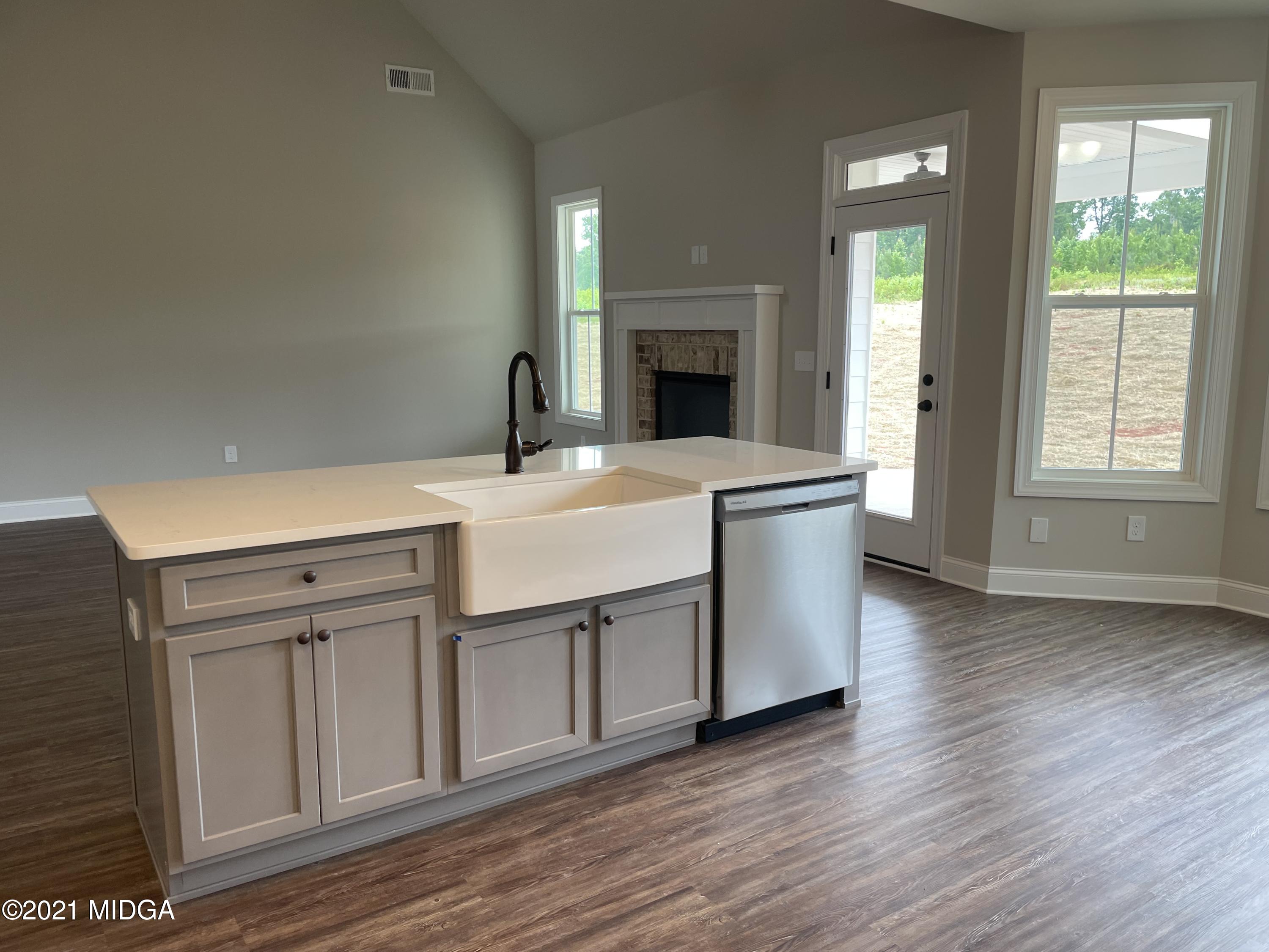 1256 Bunn Road Forsyth, GA 31029 - Photo 7 of 12 a kitchen with a sink cabinets appliances and wooden floor
