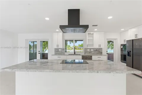a kitchen with stainless steel appliances kitchen island granite countertop a sink and cabinets