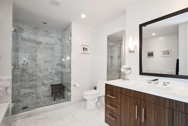 a bathroom with a double vanity sink mirror and toilet