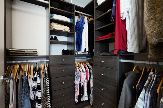 a view of walk in closet with clothes and shoes