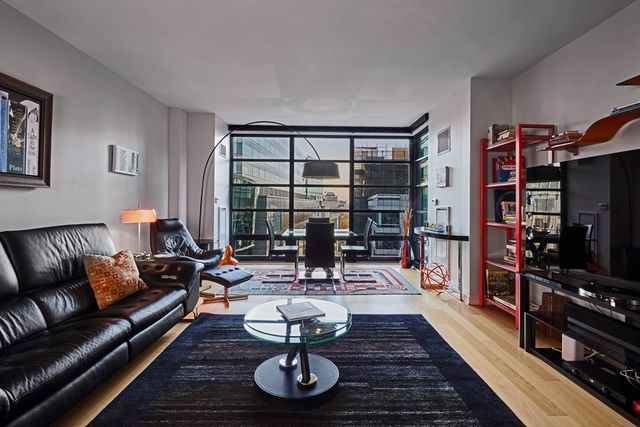 a living room with furniture a coffee table and a flat screen tv