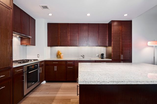 a kitchen with stainless steel appliances granite countertop wooden cabinets a stove top oven a sink and dishwasher