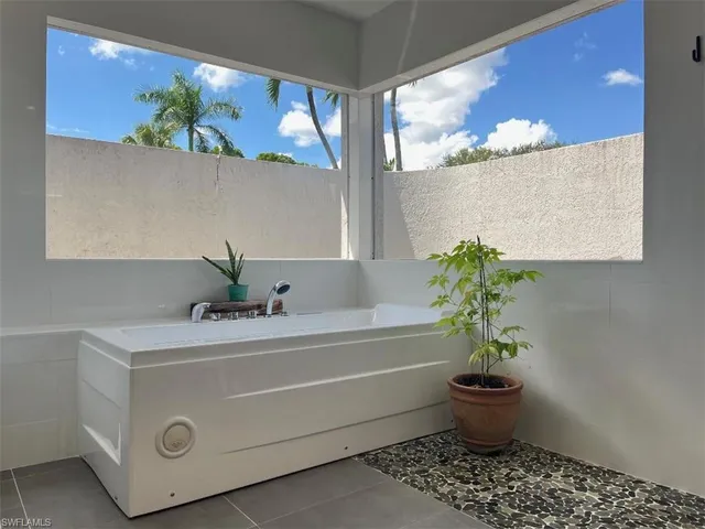 a bathroom with a bathtub and potted plant