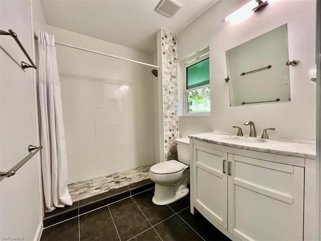 10298 Boca Circle Naples, FL 34109 - Photo 15 of 20 a bathroom with a granite countertop sink toilet and shower