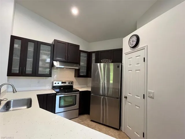 a kitchen with granite countertop a refrigerator and a sink