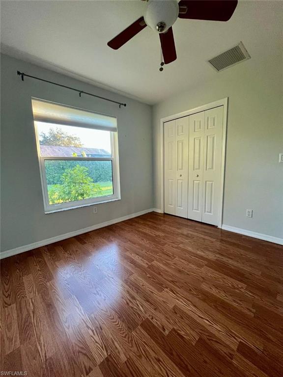 10298 Boca Circle Naples, FL 34109 - Photo 9 of 20 a view of an empty room with wooden floor and a window