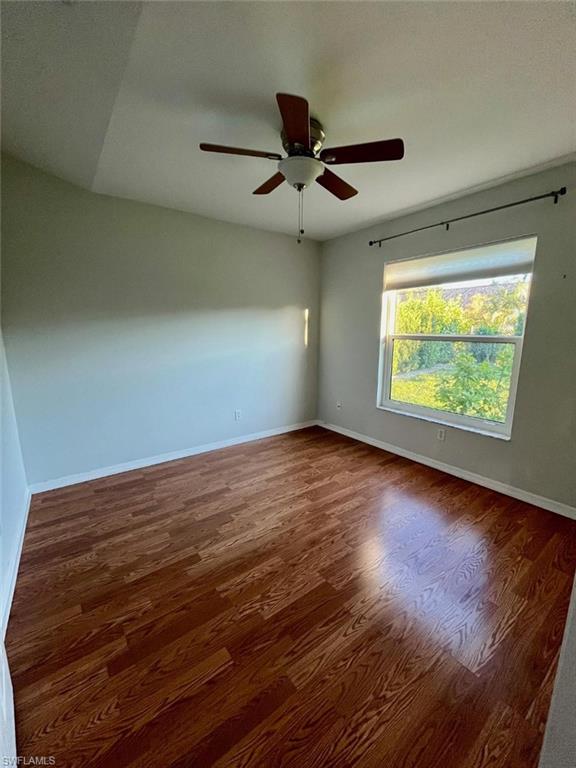 10298 Boca Circle Naples, FL 34109 - Photo 10 of 20 an empty room with wooden floor fan and windows