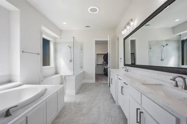 a spacious bathroom with a bathtub sink and mirror