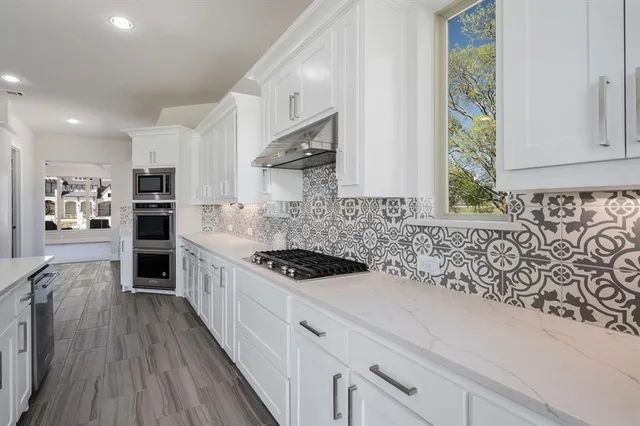 a kitchen with kitchen island granite countertop a stove and a wooden floors