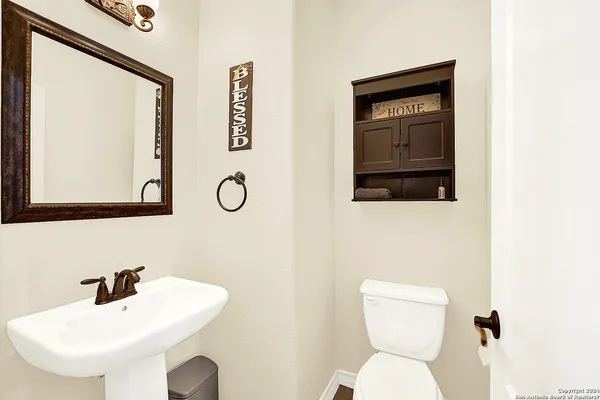 a bathroom with a toilet sink and mirror