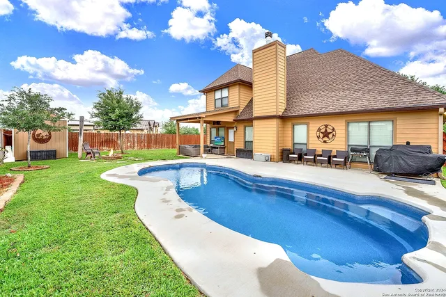 a view of a house with swimming pool having outdoor seating