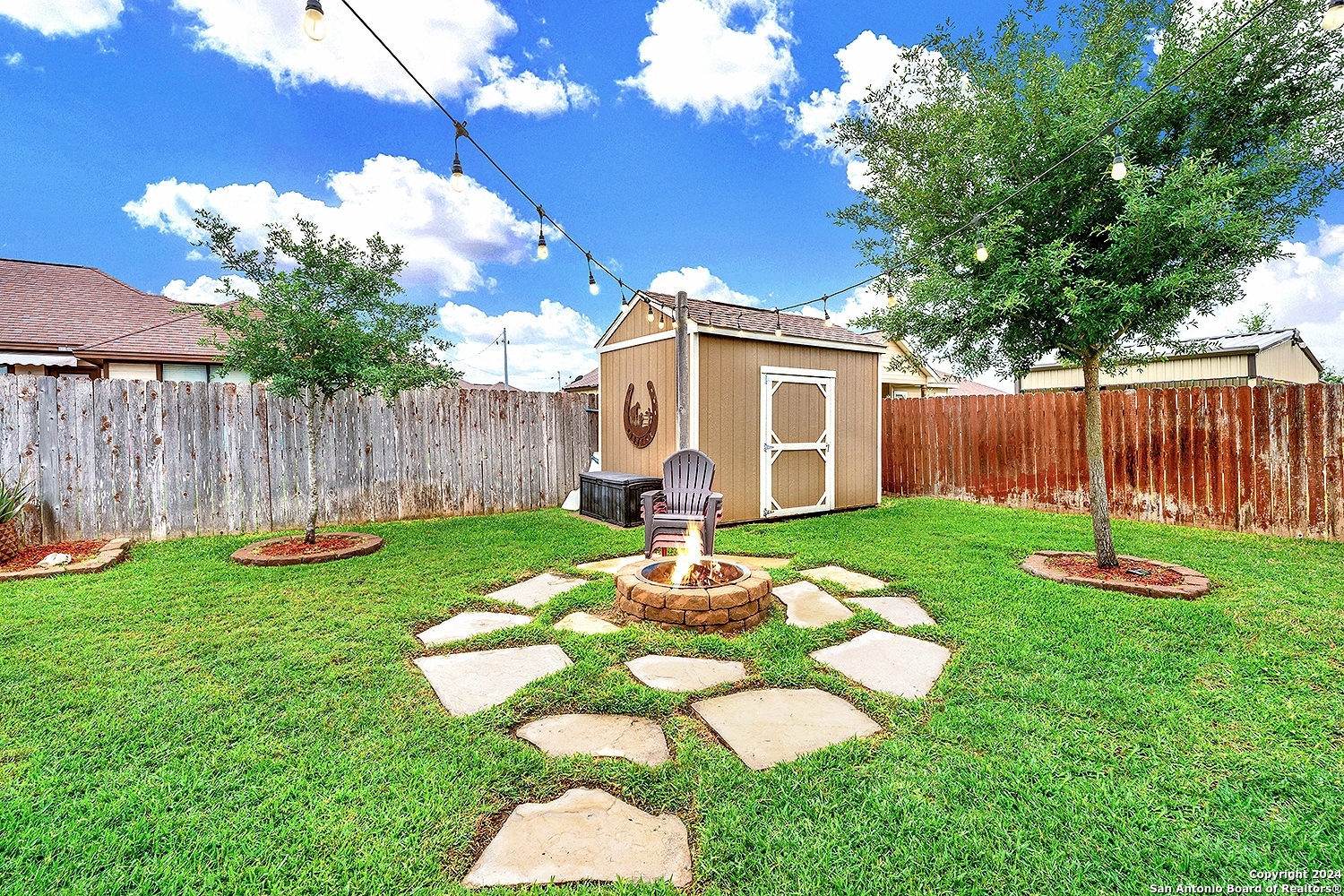 109 Park Way Poth, TX 78147 - Photo 29 of 35 a backyard of a house with table and chairs plants and large tree