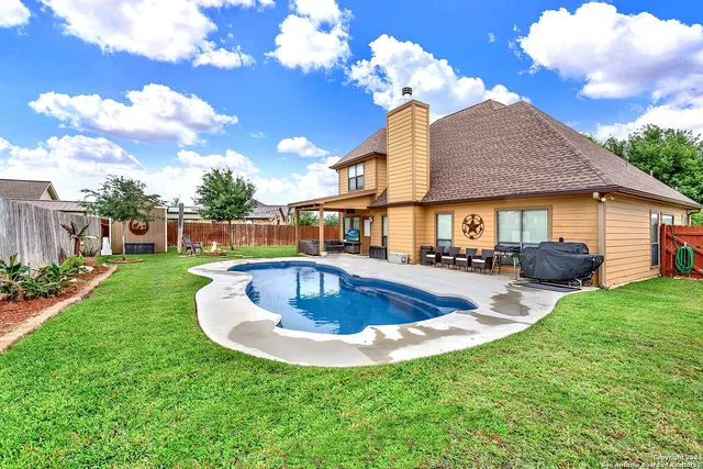 a view of a house with swimming pool yard fire pit and porch