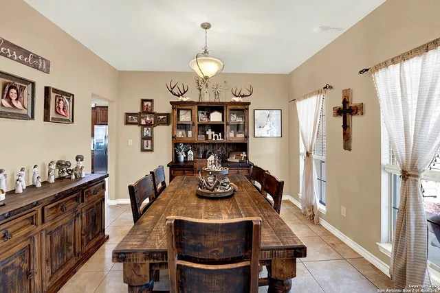 a view of a dining room and livingroom with furniture wooden floor kitchen chandelier and wooden floor