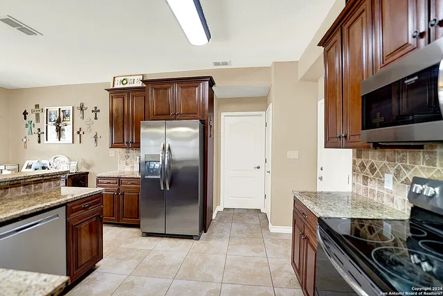 a kitchen with granite countertop a refrigerator and a stove