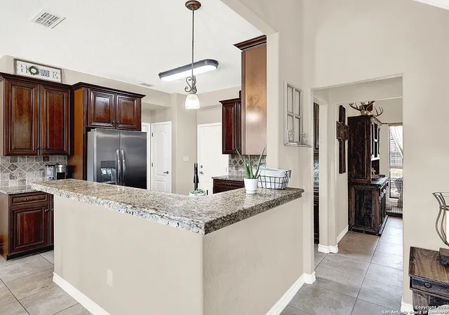 a kitchen with kitchen island granite countertop cabinets a sink stainless steel appliances and a counter top space