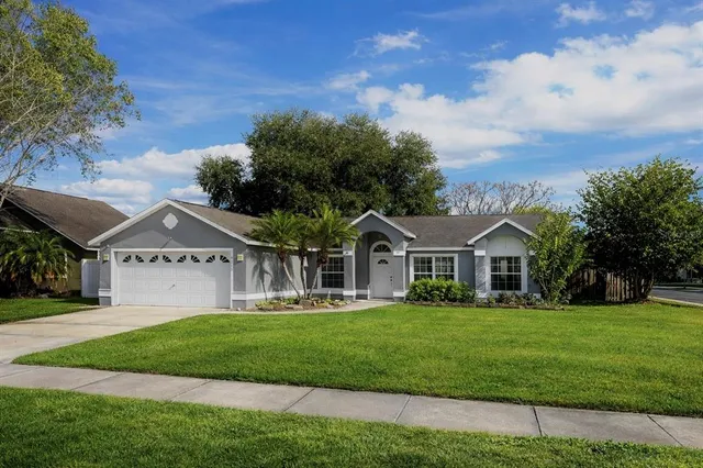 a front view of a house with a garden and trees
