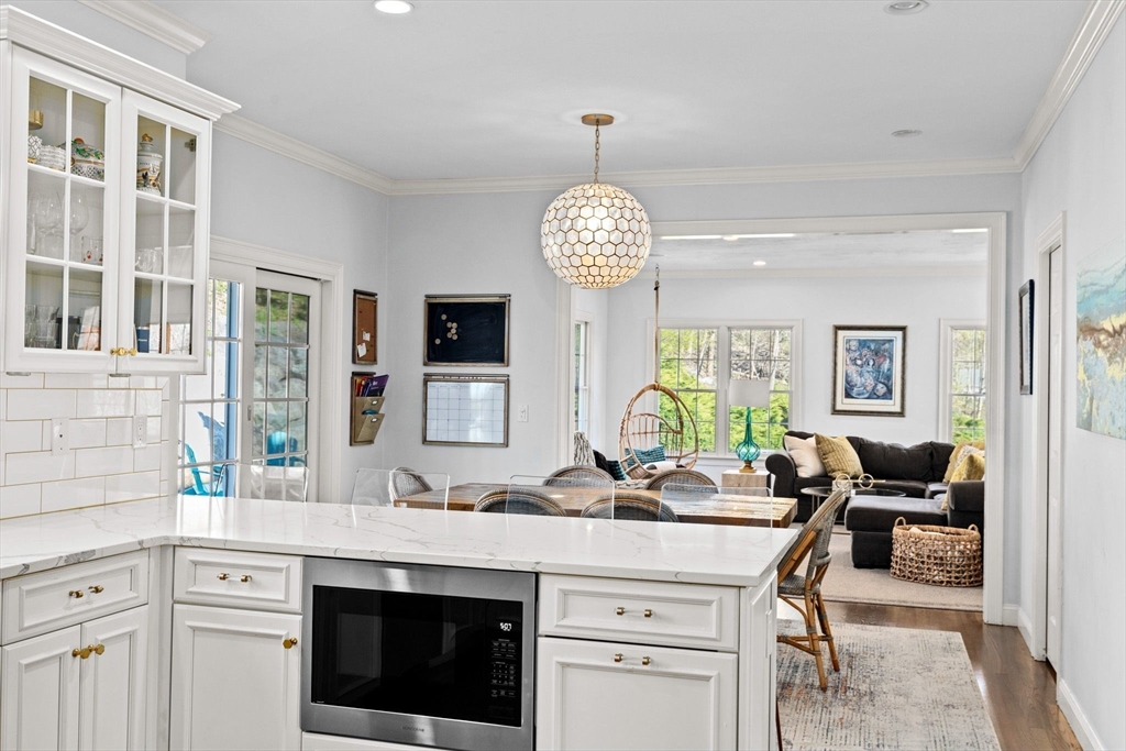 4 Baker Hill Drive Hingham, MA 02043 - Photo 15 of 40 a kitchen with a stove a sink a dining table and chairs