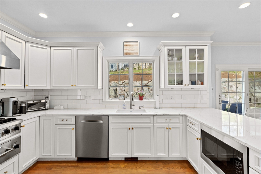 4 Baker Hill Drive Hingham, MA 02043 - Photo 10 of 40 a kitchen with granite countertop white cabinets and white appliances