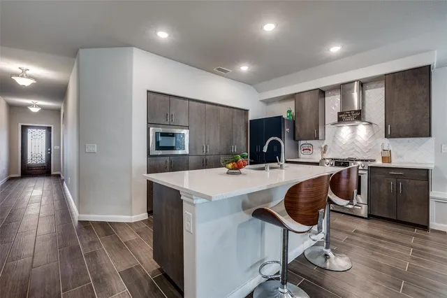 a kitchen with kitchen island granite countertop a stove and a refrigerator