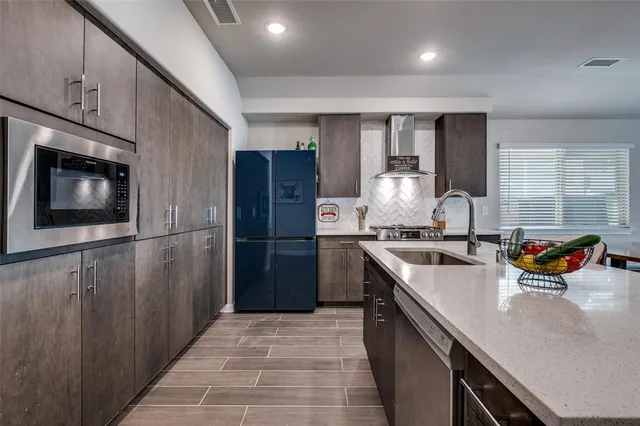 a kitchen with stainless steel appliances granite countertop a refrigerator and a sink