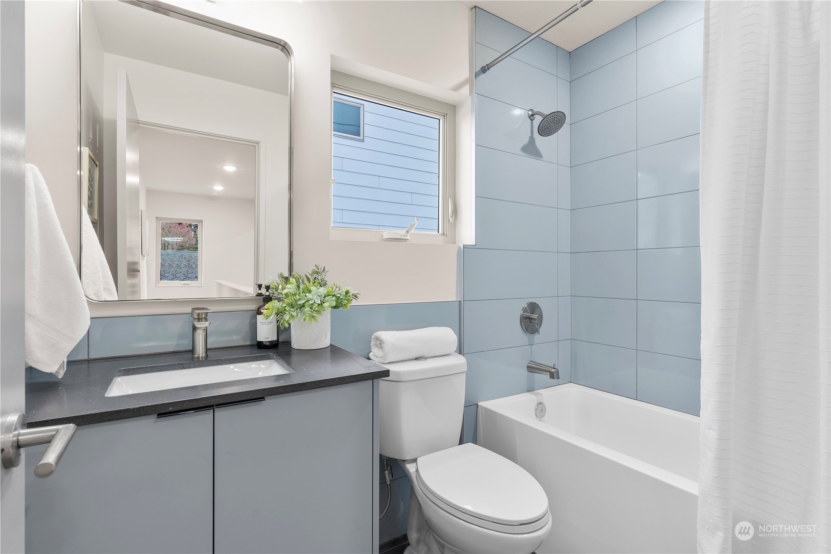 4019 51st Avenue Southwest Seattle, WA 98116 - Photo 21 of 33 a bathroom with a sink a toilet a mirror a vanity and shower