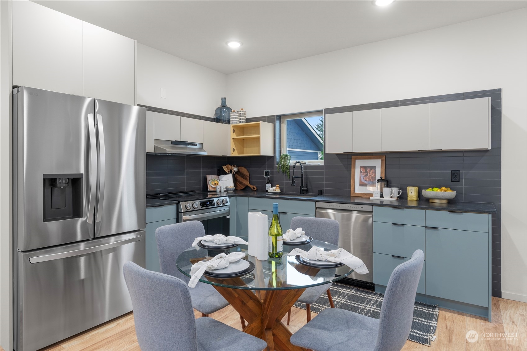 4019 51st Avenue Southwest Seattle, WA 98116 - Photo 10 of 33 a kitchen with stainless steel appliances a refrigerator a stove a dining table and chairs