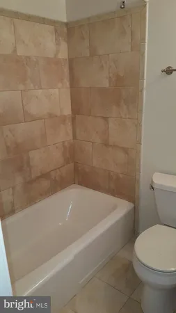 a white bath tub sitting next to a toilet