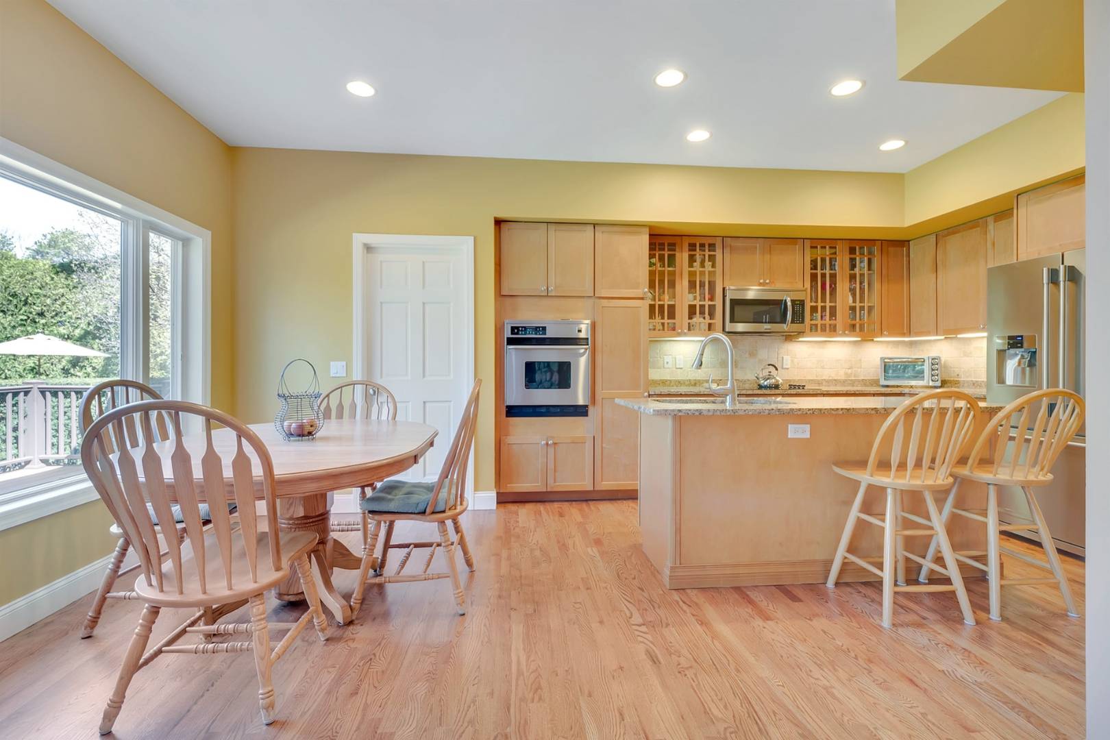 49 Bridle Path Westhampton Beach, NY 11978 - Photo 11 of 37 a dining room with stainless steel appliances furniture wooden floor and a kitchen view