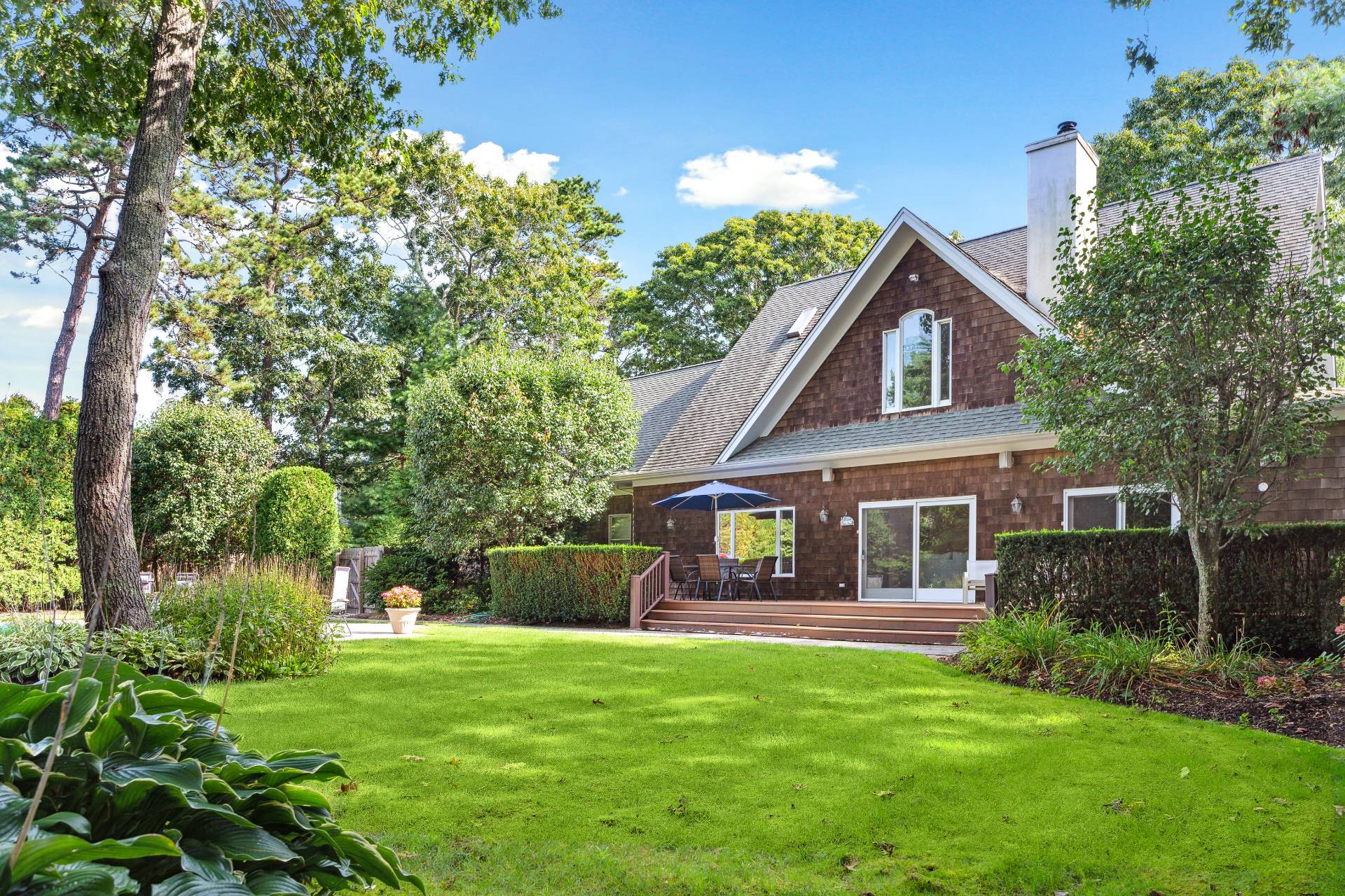 49 Bridle Path Westhampton Beach, NY 11978 - Photo 32 of 37 a front view of a house with a garden