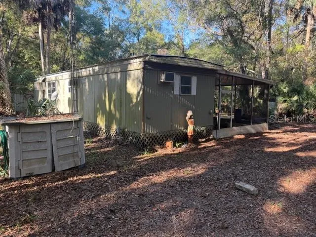 a view of a house with backyard and trees