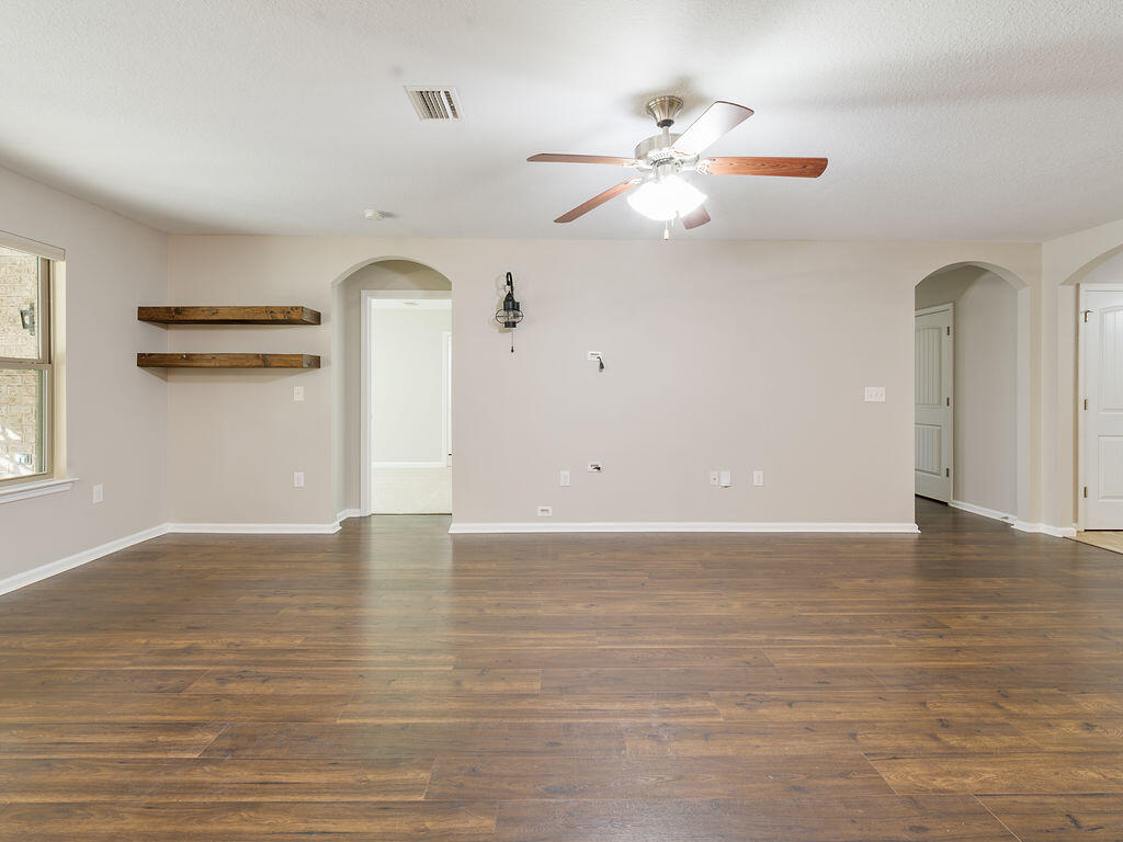4889 Spears Street Pace, FL 32571 - Photo 8 of 25 a view of an empty room with window and wooden floor