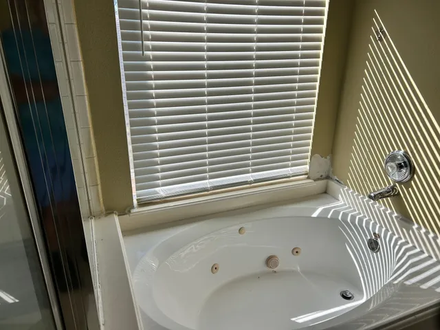 a bathroom with a bathtub and next to a window