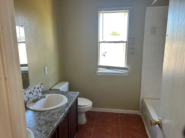 a bathroom with a sink toilet and window