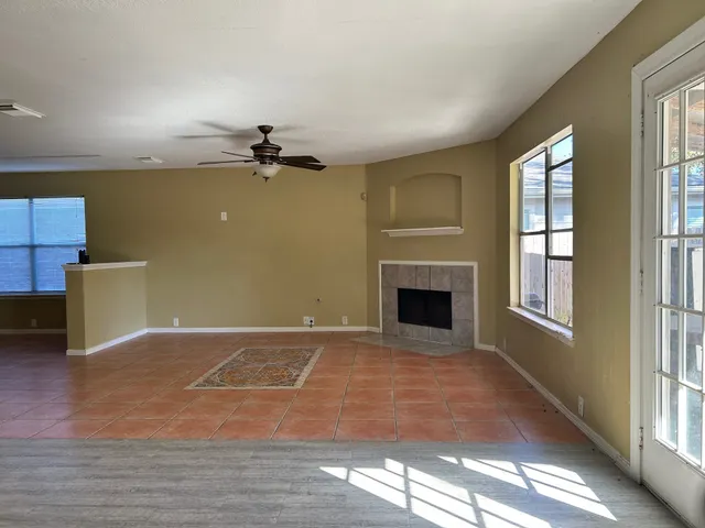 a view of an empty room with a window and a fireplace