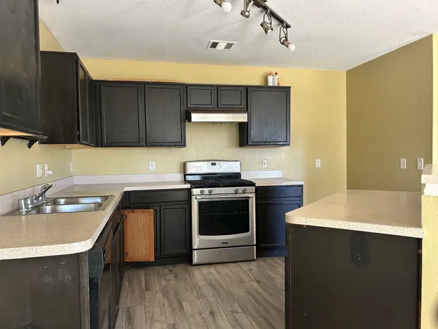 a kitchen with a sink a stove and cabinets