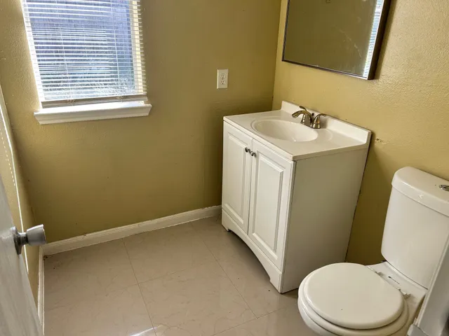 a bathroom with a sink a toilet and a mirror