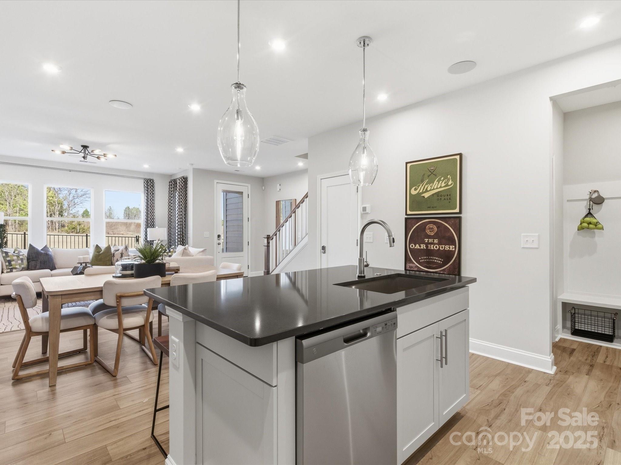 492 Nash Street Fort Mill, SC 29715 - Photo 13 of 28 a kitchen with stainless steel appliances granite countertop a stove a sink a dining table and chairs with wooden floor