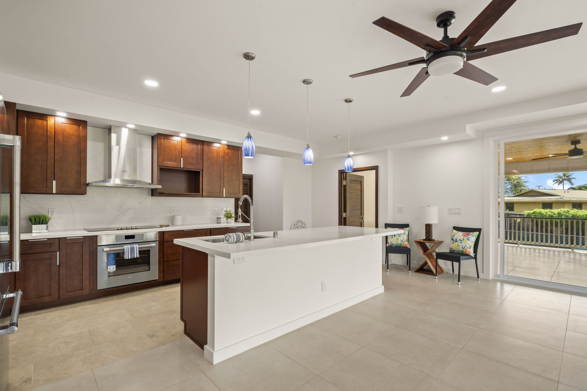 3582 Rice Street Lihue, HI 96766 - Photo 11 of 30 a large white kitchen with stainless steel appliances kitchen island granite countertop a sink and cabinets