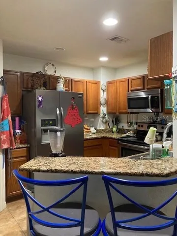 a kitchen with kitchen island granite countertop a sink cabinets and appliances