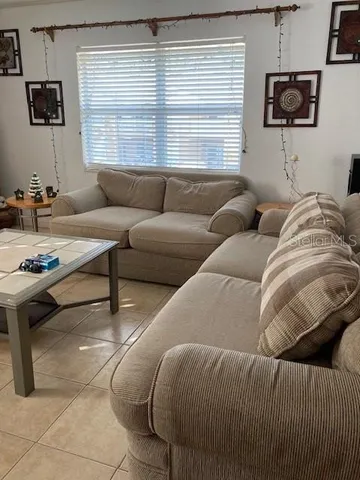 a living room with furniture a large window and a flat screen tv
