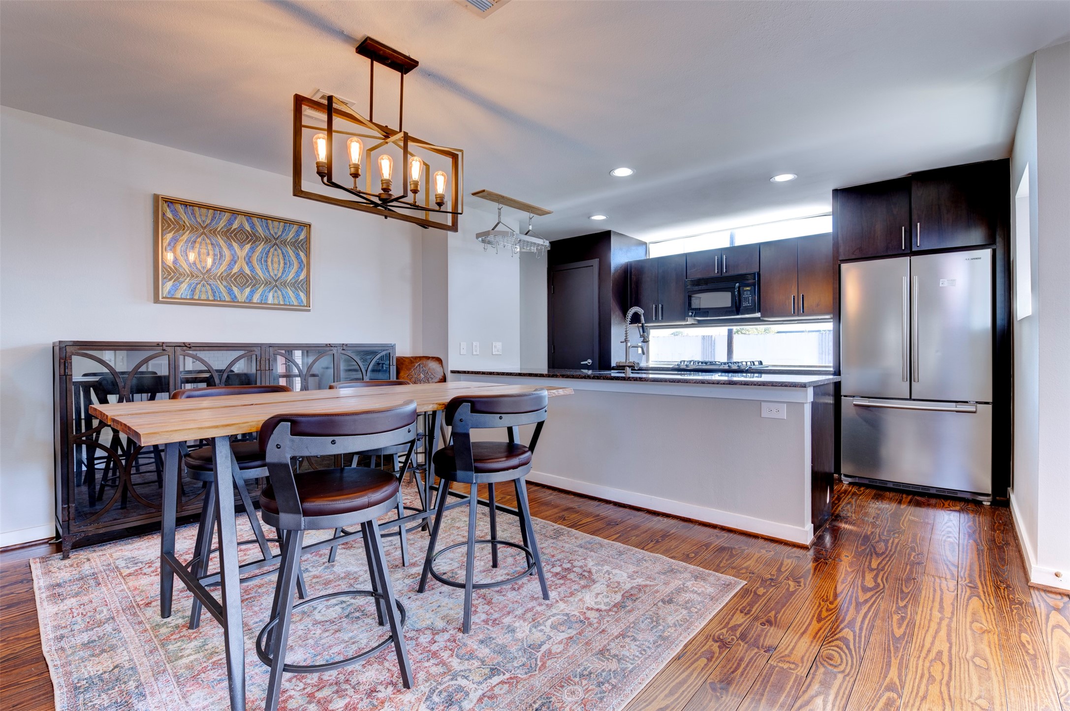 3050 Commerce Street Houston, TX 77003 - Photo 3 of 33 a kitchen with stainless steel appliances granite countertop a dining table chairs refrigerator and sink