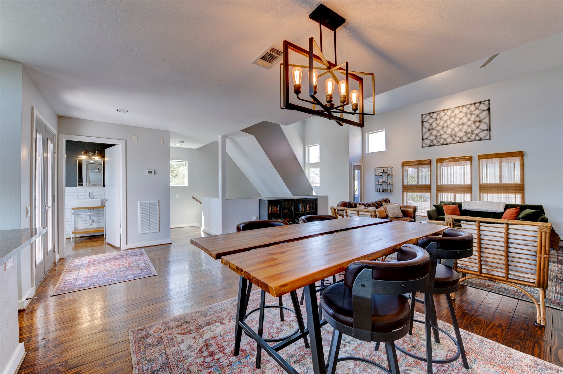 3050 Commerce Street Houston, TX 77003 - Photo 8 of 33 a dining room with wooden floor a chandelier a wooden table and chairs