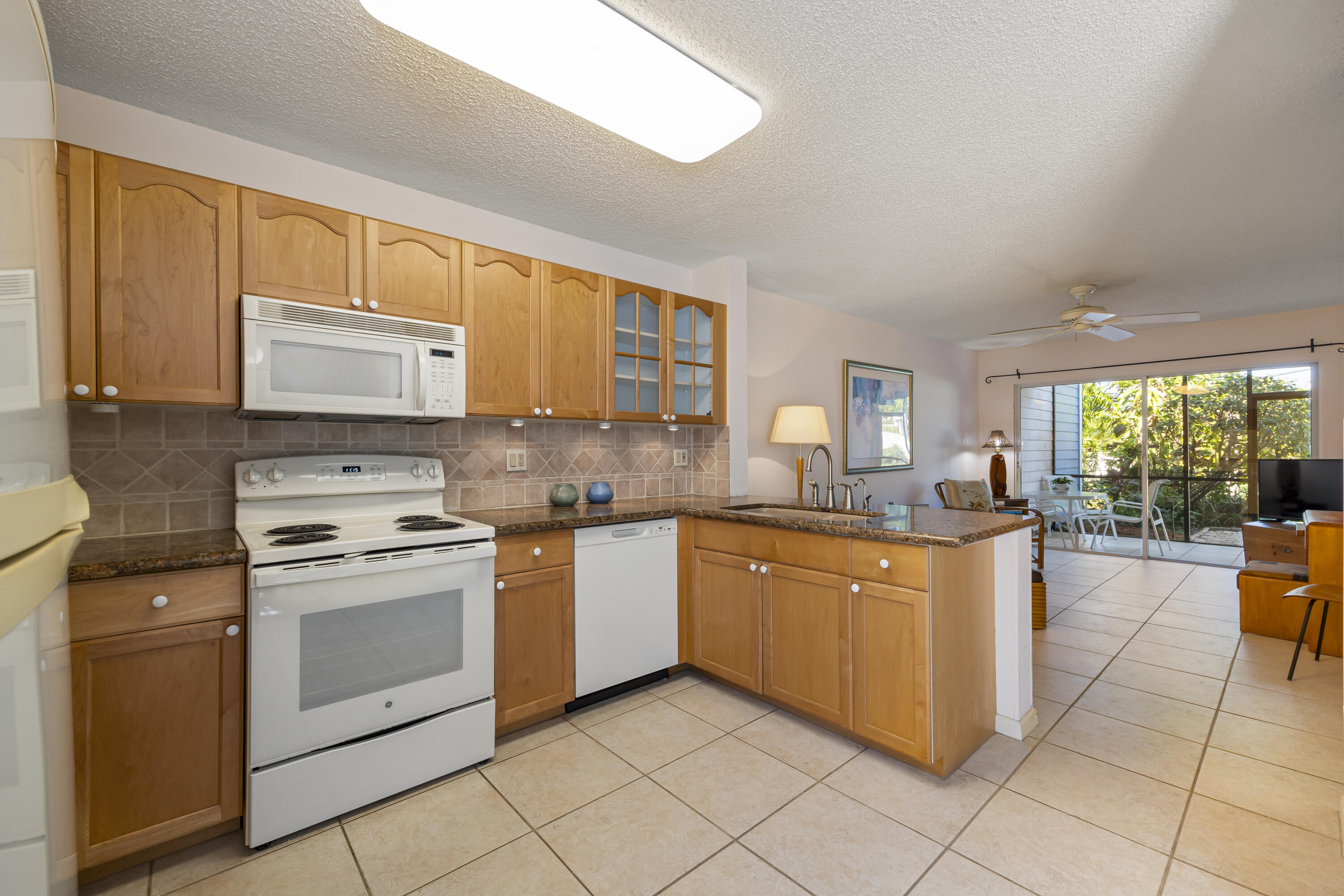 105 Ocean Dunes Circle Jupiter, FL 33477 - Photo 12 of 40 a kitchen with stainless steel appliances granite countertop a stove a sink and a microwave