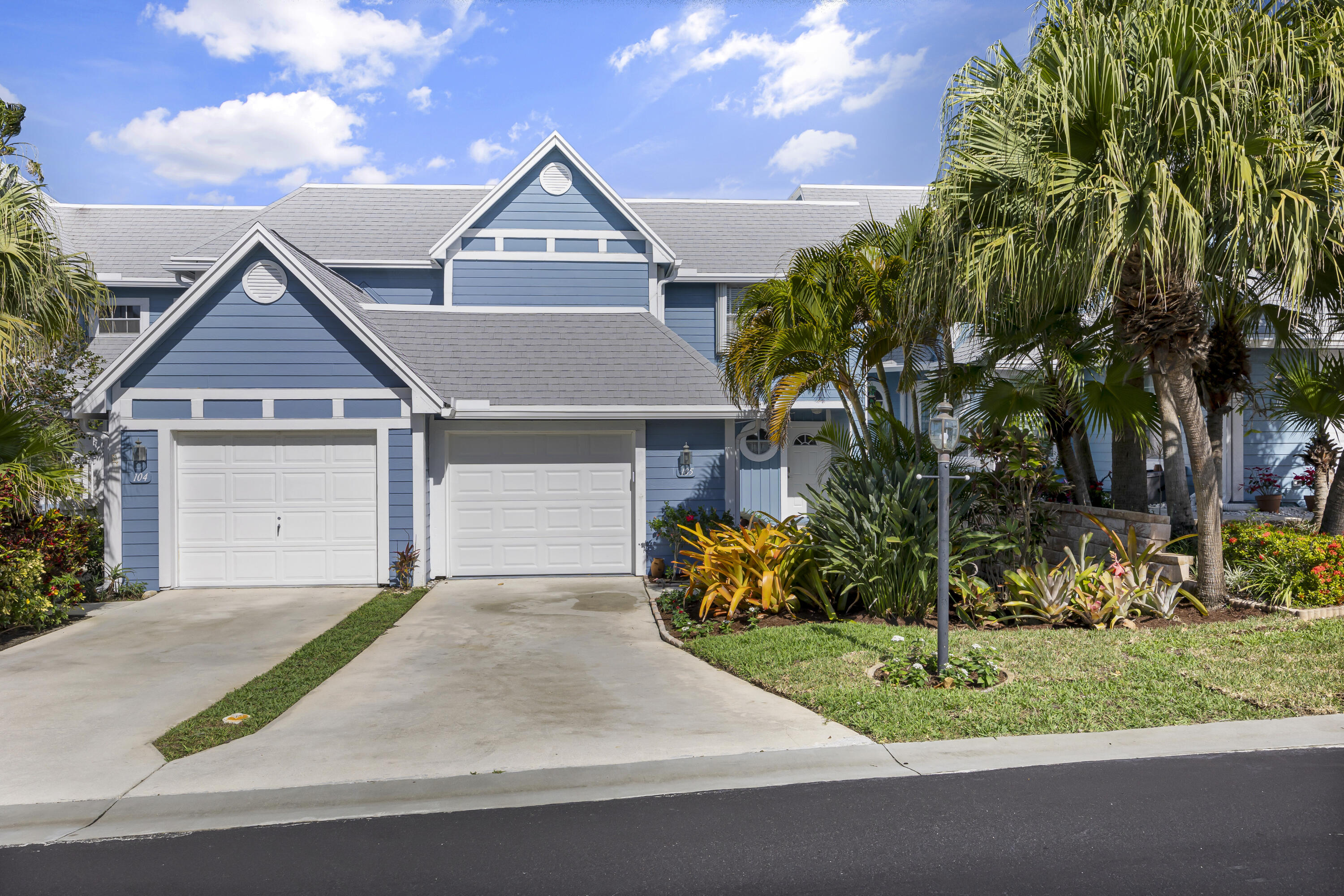 105 Ocean Dunes Circle Jupiter, FL 33477 - Photo 2 of 40 a front view of a house with a yard and garage