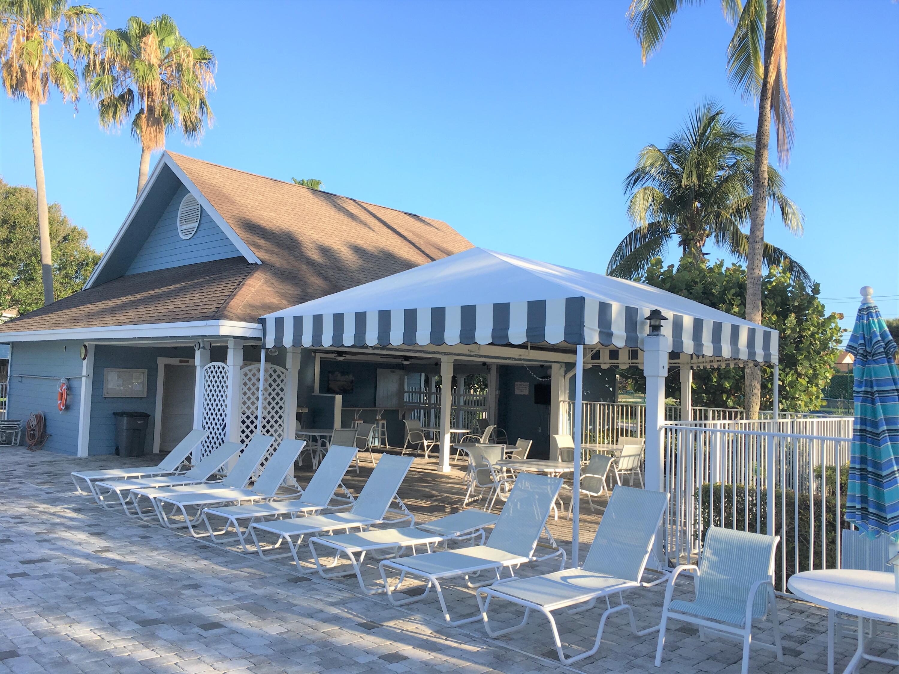 105 Ocean Dunes Circle Jupiter, FL 33477 - Photo 32 of 40 a patio with a table and chairs and potted plants