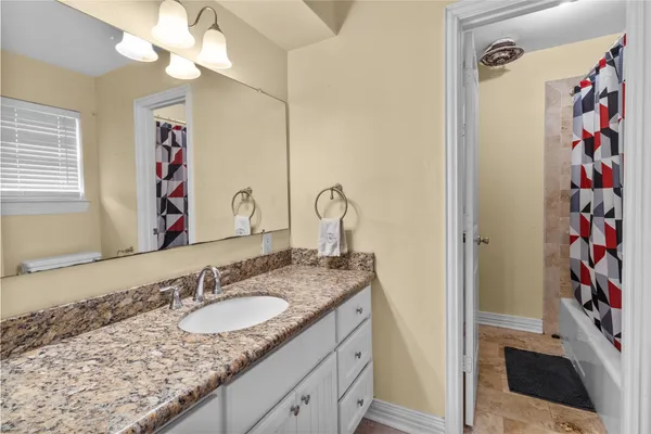 a bathroom with a granite countertop sink and a mirror
