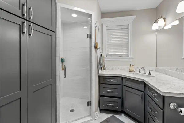 a bathroom with a granite countertop sink mirror and a shower