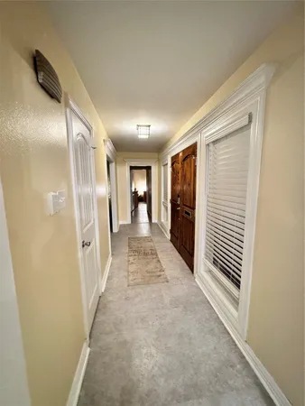 a view of a hallway with wooden shelves