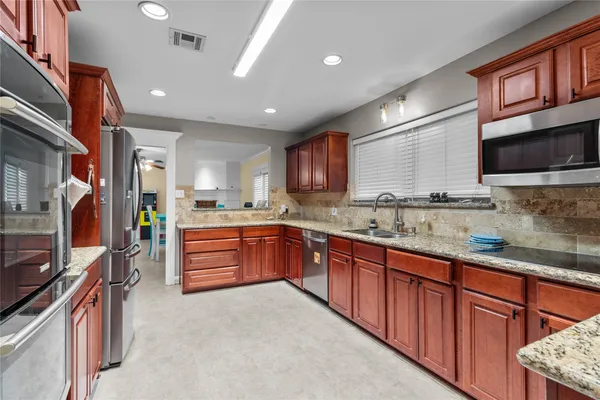 a large kitchen with stainless steel appliances granite countertop a large stove top oven a sink dishwasher and cabinets